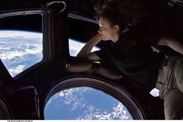 Astronaut Tracy Caldwell Dyson looking down at Earth from the cupola in the International Space Station