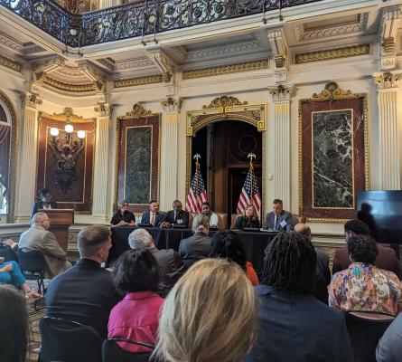 Panel of people with group of listeners