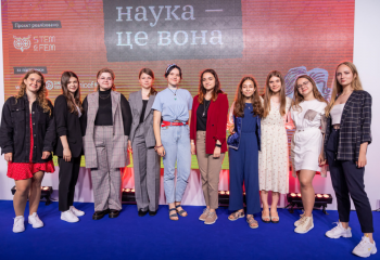 10 girls standing in front of a banner