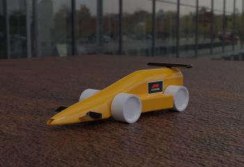 small yellow model race car with a sticker that says F1 in schools