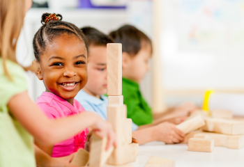 Young girl building a tower with wooden blocks