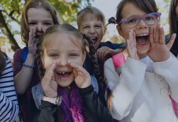 A group of girls looking ahead with hands on their face like scareaming