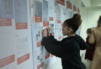 Girl standing at a board covered in papers