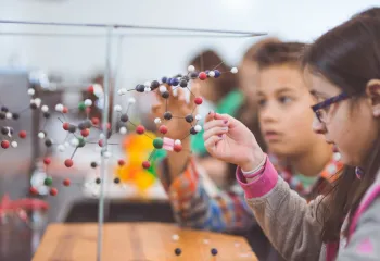 Group of children looking at a molecule model