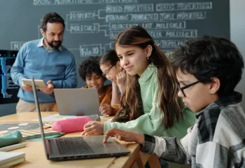Group of students in a classroom looking at laptops