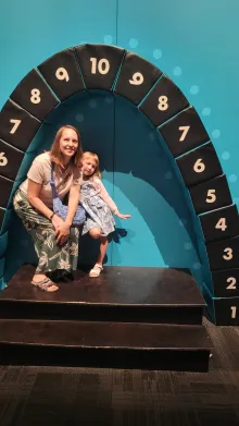 Sara with her daughter under an arch made of numbered blocks