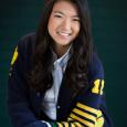 Photo of girl with long, dark hair wearing navy blue and yellow sweater