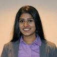 Varshini Odayar - woman with dark hair wearing gray blazer and purple shirt