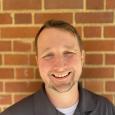 Photo of man in front of brick wall, Tyler Kearns