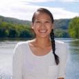 Jessica Hua - woman with dark hair in a braid standing in front of a lake