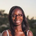 Bunmi Esho - woman with long dark hair wearing glasses