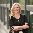 Nikki Malcom, woman with long blonde hair, smiling and wearing black shirt