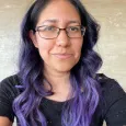 Martha Irene Saladino - Photo of woman wearing glasses with black and purple hair