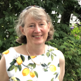 Mary Dussault - Photo of woman wearing a shirt with lemons on it in front of greenery