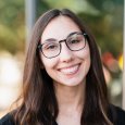 Lindly Fernandez - woman with long brown hair and glasses wearing a black top