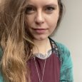 Cassandra Taylor - Woman with long brown hair wearing a teal and burgundy shirt